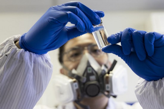 趙苗博士在上海光機所材料實驗室內觀察實驗材料（2月29日攝）。