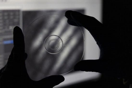 趙苗博士在上海光機所光學實驗室向記者展示“超級光盤”（2月29日攝）。